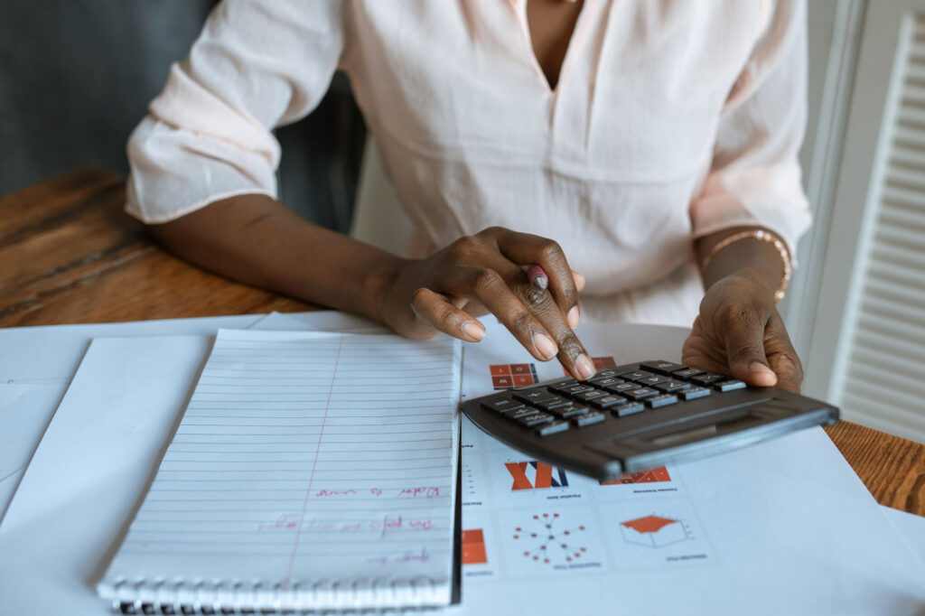 Hands on a calculator taking notes