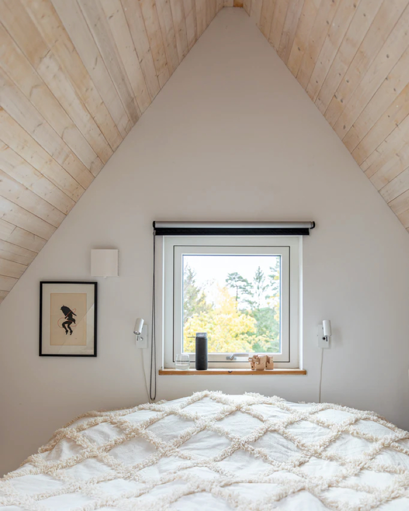 Room in a loft looking over the bed towards the view out of the window